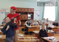 A child handles a Kalashnikov rifle in a school in the village of Topki in Russia's Kemerovo Region / Source: Agentstvo