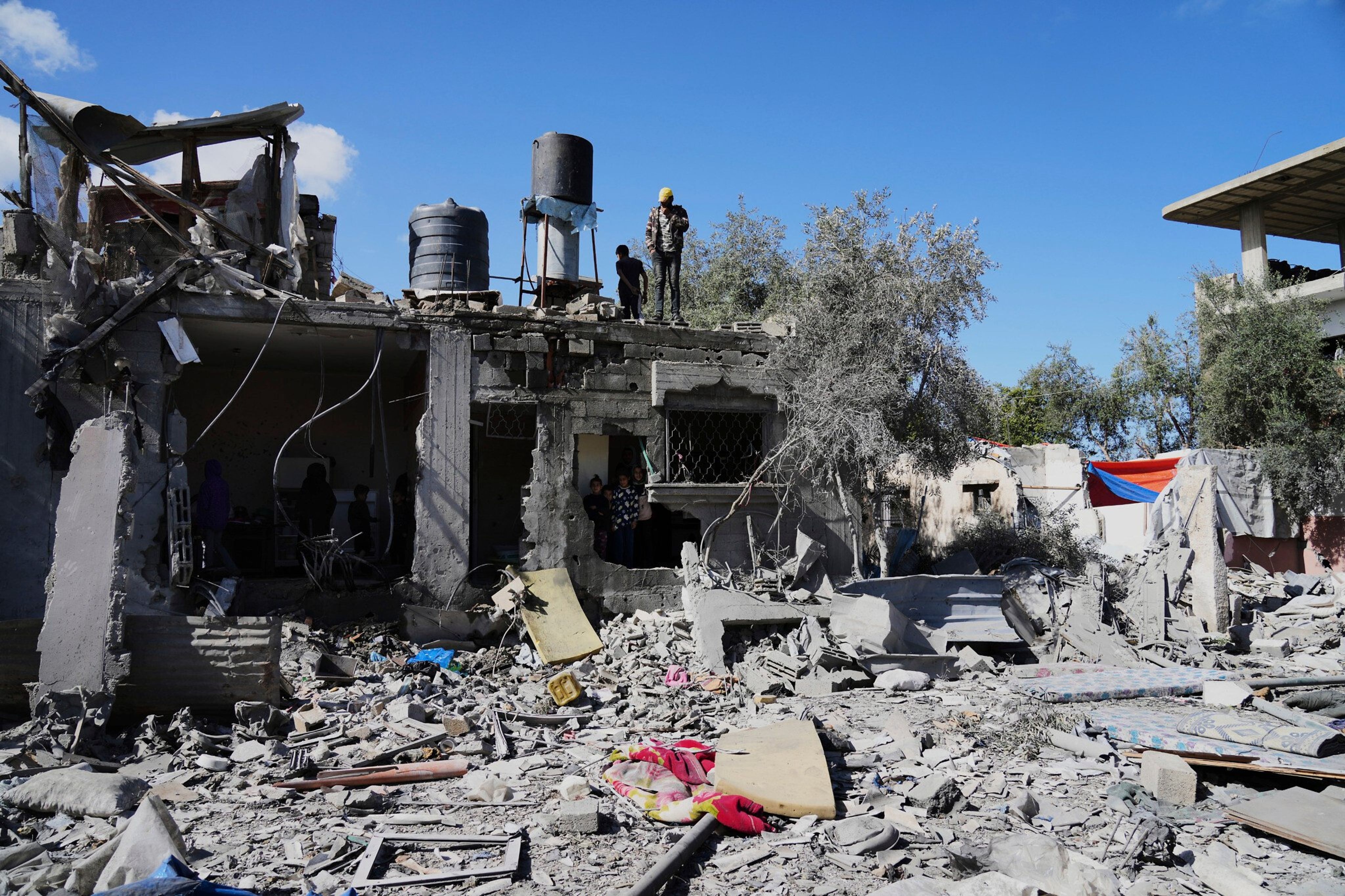 Residents of Gaza inspect a house destroyed by an Israeli airstrike in the city of Deir al-Balah on March 19, 2025.
