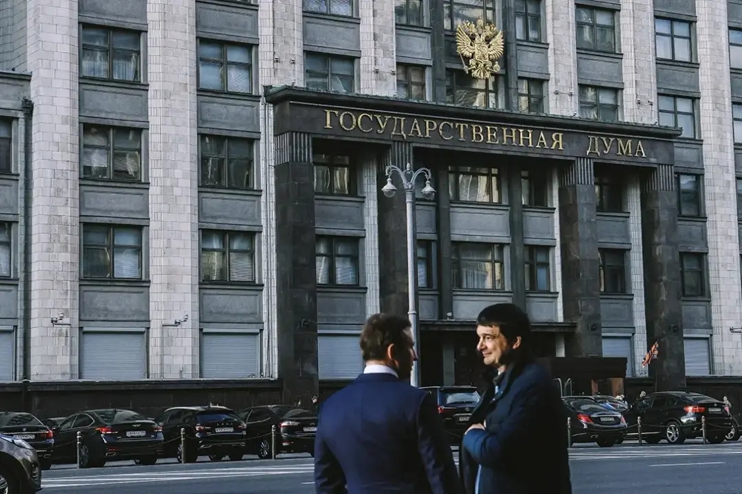 Two men talking in front of the State Duma building in central Moscow. Photo: Andrey Lyubimov / RBC