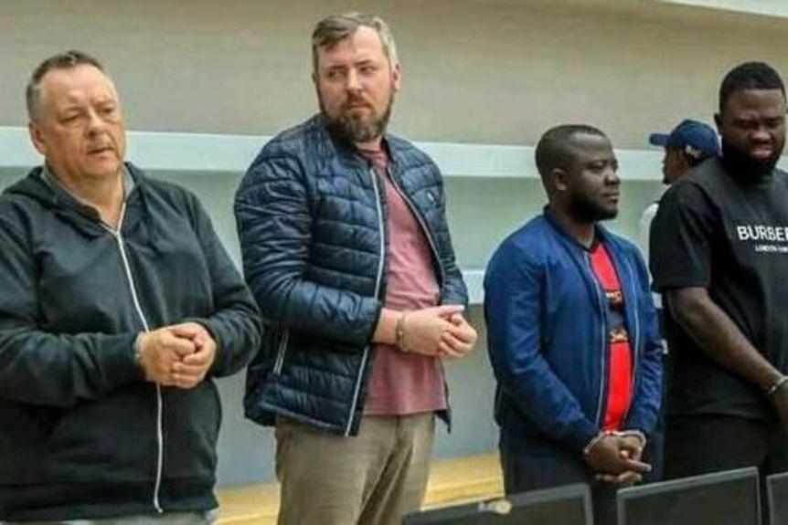 Фото: (слева направо) россияне Лев Лакштанов и Игорь Ратчин на суде вместе с гражданами Анголы Амором Карлосом Томе и Франсиско Оливейрой