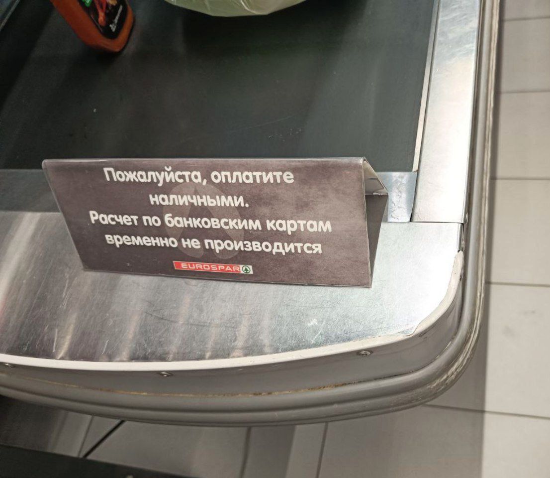 A sign at a checkout counter at the EUROSPAR supermarket chain reads “Please pay in cash. Bank card transactions are temporarily unavailable.”