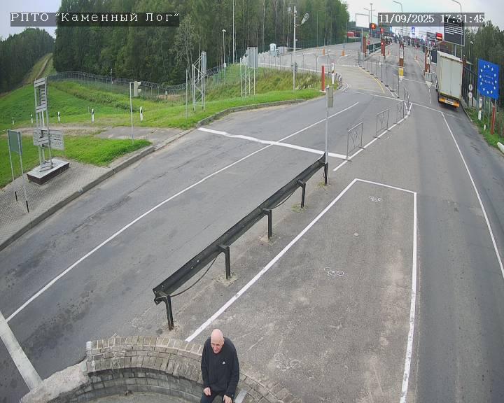 Mikola Statkevich in the "neutral zone" between the state borders of Belarus and Lithuania. The entry point to the latter, marked by a sign with an EU flag, can be seen in the background.