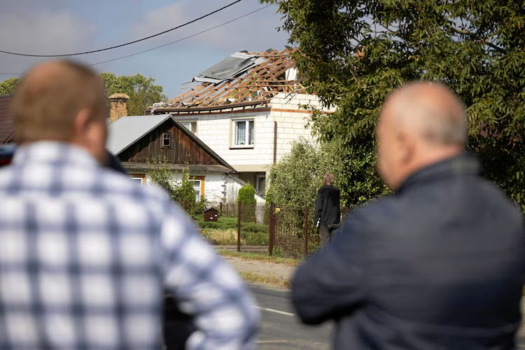 Onlookers look at the damaged home in eastern Poland after the Russian drone incursion on Sept. 10