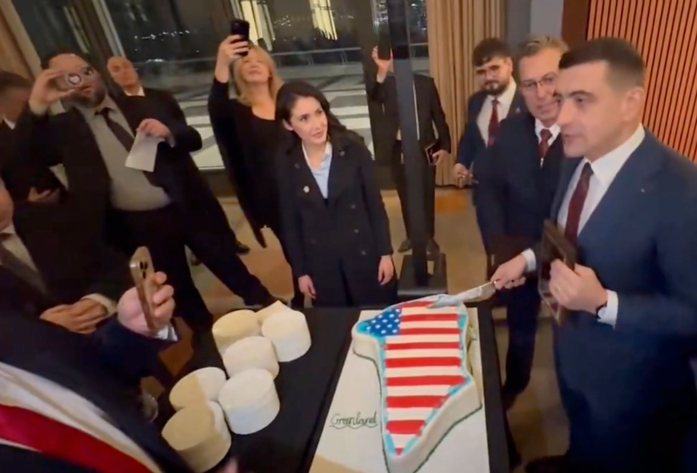 George Simion (right) and Anna Paulina Luna cut a Greenland-shaped cake